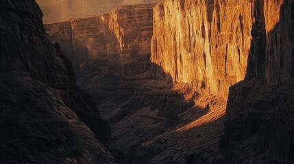 Poster - A stunning sunset illuminates dramatic canyon cliffs, casting vibrant colors over rugged terrain and deep shadows in the valley