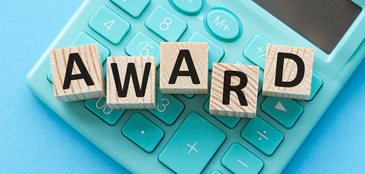 Word Award with wooden cubes on keyboard, light blue background