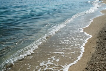 Poster - Gentle waves lap against a sandy shore under bright sunlight near a tranquil ocean