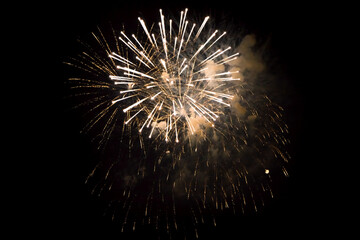 Wall Mural - white yellow fireworks closeup in black background.