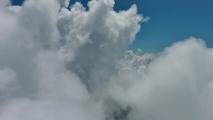 Wall Mural - Flying through white fluffy clouds