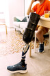 © ADDICTIVE STOCK - Man with prosthetic leg sitting comfortably in living space