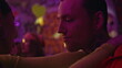 © stockbusters - Cool guy dancing girlfriend in neon disco lights closeup. Tattooed man party