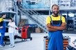 © DC Studio - Portrait of smiling african american engineer in auto repair shop tasked with changing cars brake fluid. Experienced worker in garage ready to start doing checkups on vehicles in garage workspace