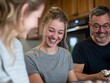© DeDeEr - Happy family laughing together in kitchen.