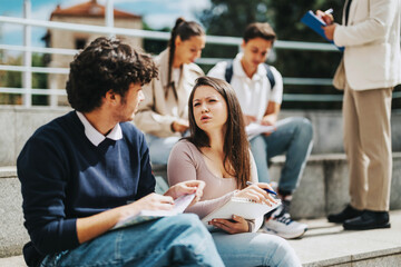 Poster - A group of high school students working together outdoors, receiving guidance from a teacher. They are focused on problem-solving and collaboration in a sunny setting.