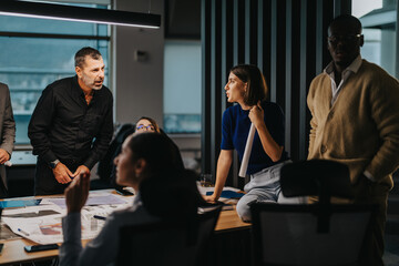 Wall Mural - A diverse group of colleagues brainstorming and discussing strategies at an office meeting. The atmosphere is dynamic and focused, highlighting teamwork and collaboration in a business environment.