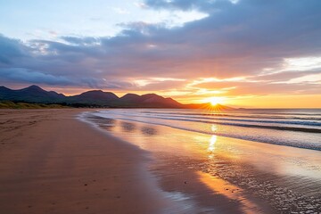 vibrant sunset over sandy beach and mountains.