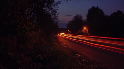 Poster - The peaceful stillness of the countryside is broken only by the passing car light trails that add an element of liveliness to the surroundings.