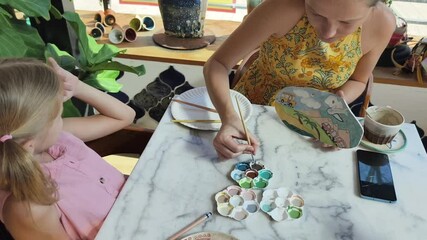 Wall Mural -  A young mother and her daughter enjoy a creative art session at home 