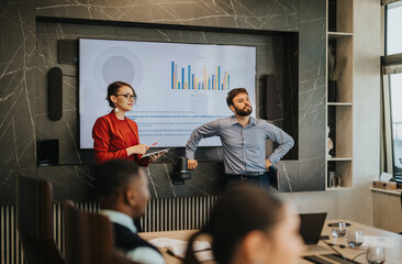 Wall Mural - A confident business team presents financial data in a modern conference room. The scene depicts a multicultural group of business people engaging in a professional presentation with charts and graphs