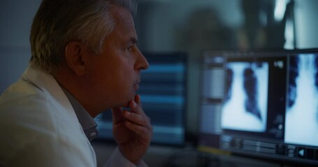 Aufkleber - Portrait of Caucasian Male Radiologist Examines Chest X-rays on Multiple Screens in a Dark Medical Office. Healthcare Professional Focused on Analyzing Detailed Medical Imagery of a Patient