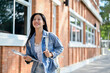 © bongkarn - A charming Asian female student going to her classroom, walking in her university outdoors area.
