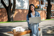 © bongkarn - A positive Asian female college student sits on a bench at her university, using her laptop to work.