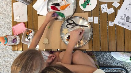 Wall Mural - Mother and her daughter paint Halloween cookies 