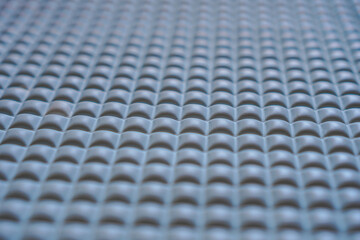 Poster - Close-up view of a gray textured surface with a repeating pattern. The image is abstract and shows detail in texture. Abstract Gray Textured Surface Patterned Mat.