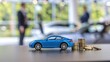 © abu - A miniature blue car beside coins in a dealership setting, symbolizing finance and purchasing.