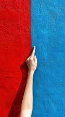 Wall Mural - A hand reaches out to touch the vibrant red and blue wall, creating a striking contrast, AI