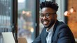 © Anas - Smiling African American Man Working on Laptop in Cafe