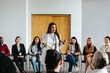 © Jacob Lund - Female instructor addressing a diverse group during a seminar in a bright conference room