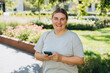 © mdyn - Happy woman chatting on phone and relaxing outdoors. Urban people concept. Smiling woman text messaging on smart phone at sunny day.