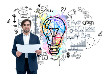 Poster - A businessman in a suit holding documents, standing in front of sketches of a colorful light bulb and business icons on a white background. Concept of creativity and planning