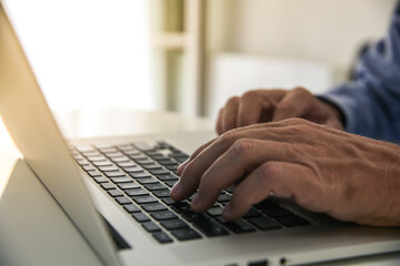 Wall Mural - Closeup man hands typing on computer keyboard. Businessman using laptop at home. Office workplace