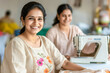 © PRASANNAPIX - indian women smiling while working on sewing machine in textile factory.