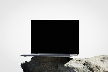 Wall Mural - scene with a opened laptop with a blank screen on the rock