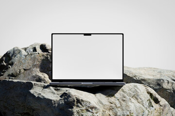 Wall Mural - scene with a opened laptop with a white blank screen on the rock