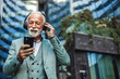 © Jelena Stanojkovic - Mature, professional and walking in urban town with radio, streaming song or travel in road. Businessman, happy and headphones of a worker or employee enjoying wireless connectivity in the outdoors.