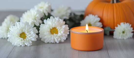Aufkleber - Autumn still life with a candle, pumpkin, and white chrysanthemums creating a cozy atmosphere on a wooden table.