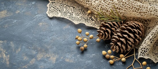 Poster - Charming winter scene with pine cones and lace on textured surface perfect for Christmas greetings and seasonal decorations