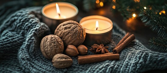 Poster - Cozy Christmas ambiance with candles nuts cinnamon sticks and fir branches on knitted fabric creating a warm home decor atmosphere