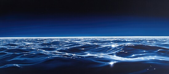 Poster - Vast ocean expanse under dark blue twilight showcasing shimmering waves and serene sky reflections