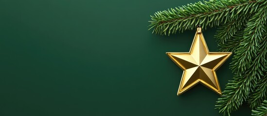 Poster - Golden star-shaped Christmas ornament hanging from a pine branch on a dark green background for festive holiday decorations