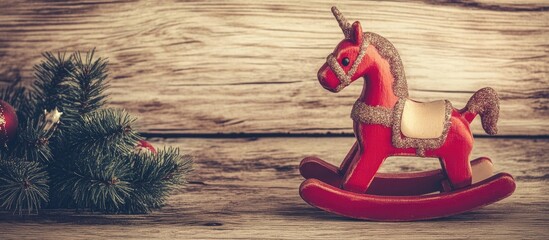 Aufkleber - Vintage rocking horse Christmas decoration on wooden background with pine branches and ornaments in warm tones.
