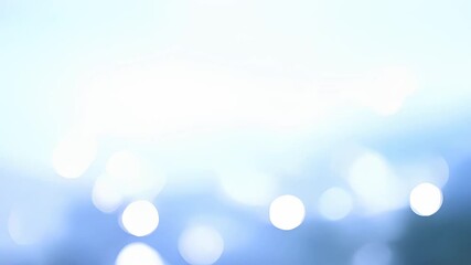 Abstract blue bokeh background with bright light spots.