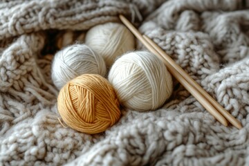 Wall Mural - Soft balls of yarn and knitting needles sit on a warm, chunky knit blanket, ready for a relaxing crafting session