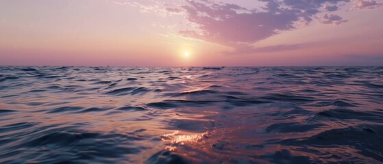 Wall Mural - A breathtaking sunset casts a delicate pink glow across the vast ocean waves, capturing the serene majesty of twilight over the water.