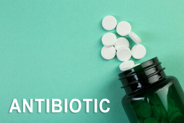 Wall Mural - Bottle of antibiotic pills on aquamarine background, top view