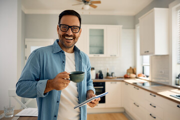 Wall Mural - Happy entrepreneur enjoying in coffee break while working at home and looking at camera.