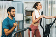 © InfiniteFlow - Athletic and sporty young couple or fitness buddy running on running machine together, home body workout exercise session as healthy sport lifestyle at home. Gaiety home exercise workout training.