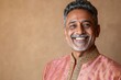 © Nikolai - Smiling Indian man in traditional attire with warm backdrop