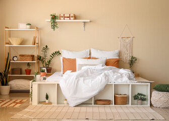 Wall Mural - Big comfortable bed, houseplants and shelving units in interior of bedroom