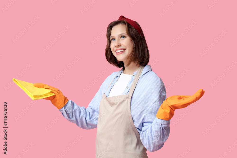 Pretty young housewife with rag on pink background