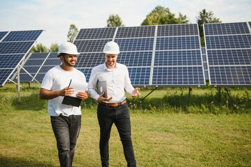 Indian engineer and businessman planing new ecology project. around solar panel