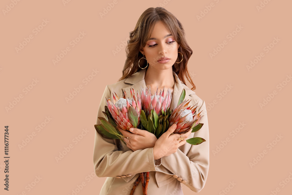 Beautiful young woman with protea flowers on beige background