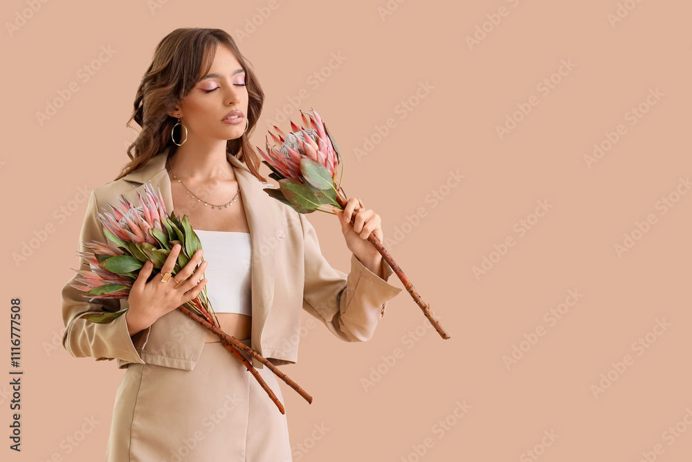 Beautiful young woman with protea flowers on beige background