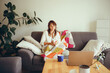 © Anna Tsukanova/Stocksy - Woman watching show sitting on the couch in living room with hot drink